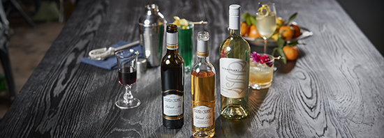 Table topped with three wine bottles and glasses of wine